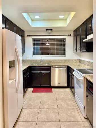 a kitchen with granite countertop a refrigerator and a sink