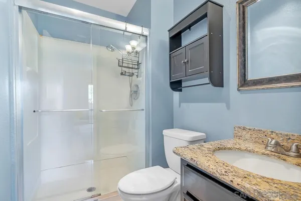 a bathroom with a granite countertop sink toilet and shower
