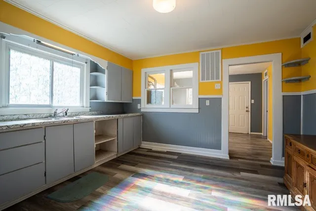 a kitchen with granite countertop a sink and cabinets