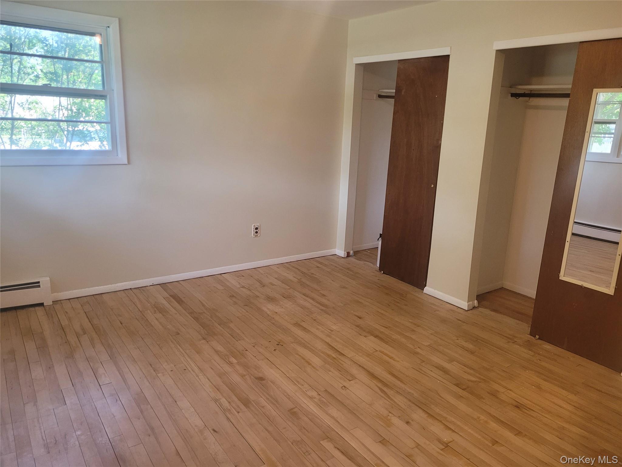 8 Cornell Road East Patchogue, NY 11772 - Photo 16 of 18 an empty room with wooden floor and a window