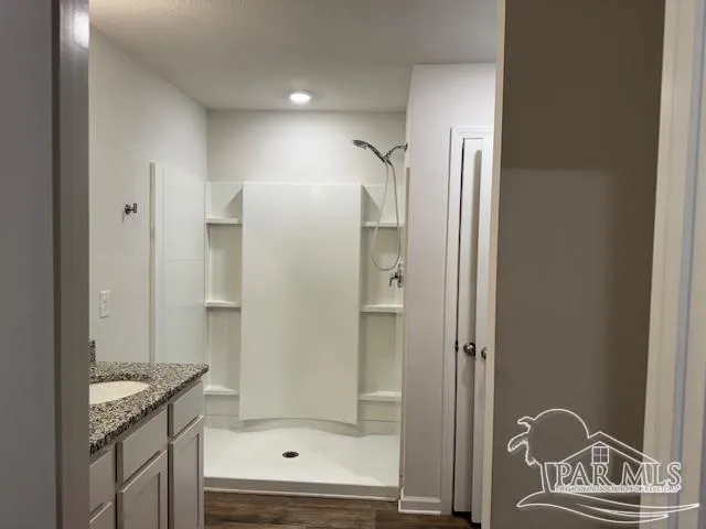 a bathroom with a granite countertop bathtub shower sink and mirror