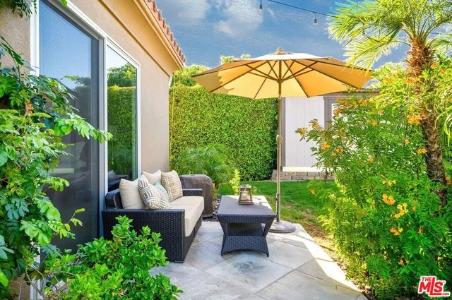 a view of a chair and table under an umbrella in patio