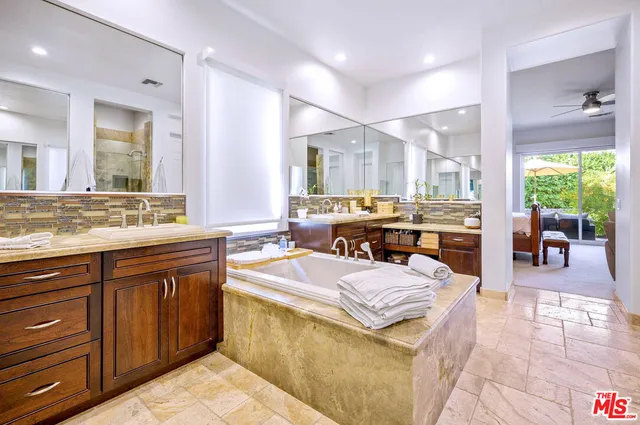 a large bathroom with a large tub sink and large mirror