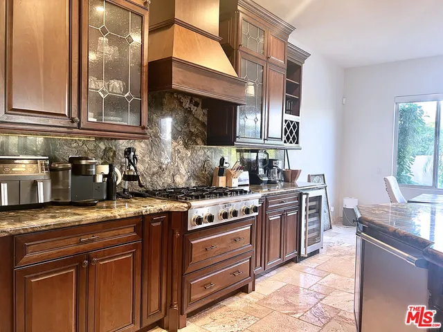 a kitchen with stainless steel appliances granite countertop a stove a sink and a microwave