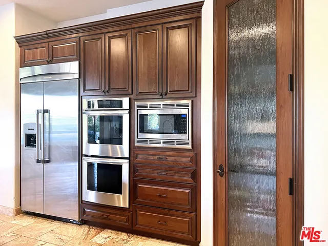 a view of a refrigerator in kitchen and wooden door