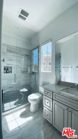 a bathroom with a sink a toilet and shower