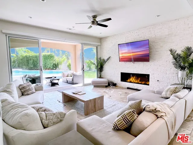 a living room with furniture fireplace and a large window