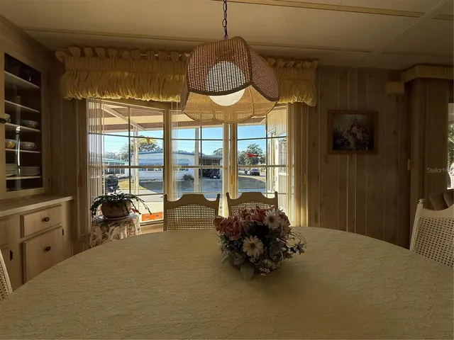 a dining room with furniture a rug wooden floor and windows