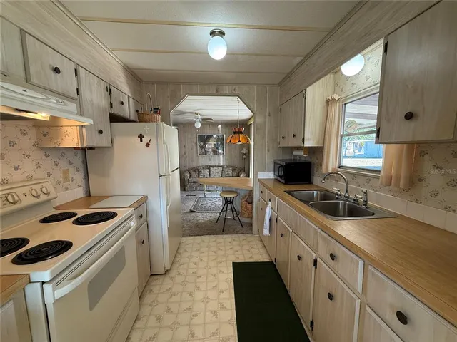 a kitchen with stainless steel appliances a sink stove and refrigerator