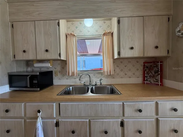 a kitchen with granite countertop a sink a stove and cabinets