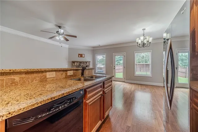 a kitchen with granite countertop a sink cabinets and wooden floor