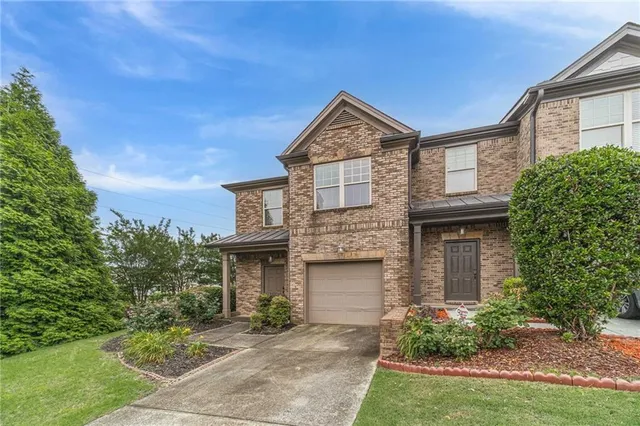 a front view of a house with a garden and plants