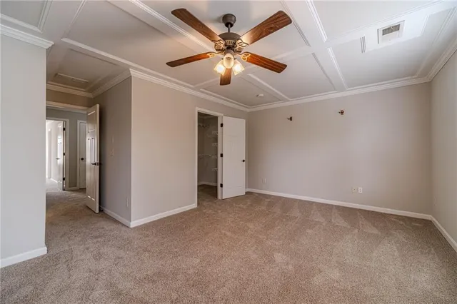 a view of an empty room with window and a ceiling fan