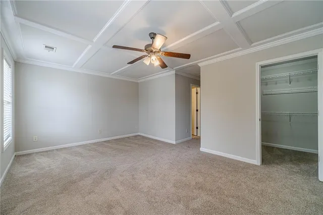 an empty room with closet and a ceiling fan
