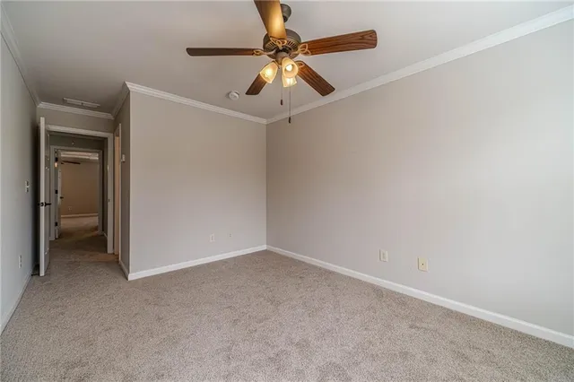 an empty room with a ceiling fan and a fan