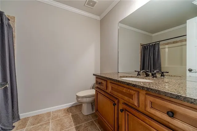 a bathroom with a granite countertop sink a toilet and a mirror