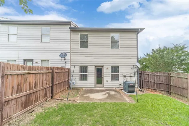 a view of backyard with wooden fence and a large tree
