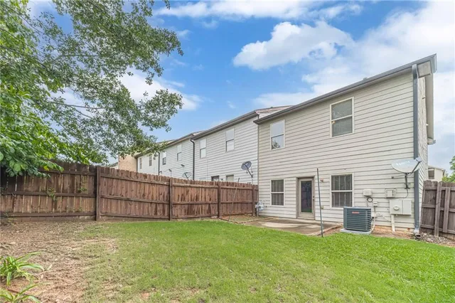 a view of a backyard with table and chairs and wooden fence