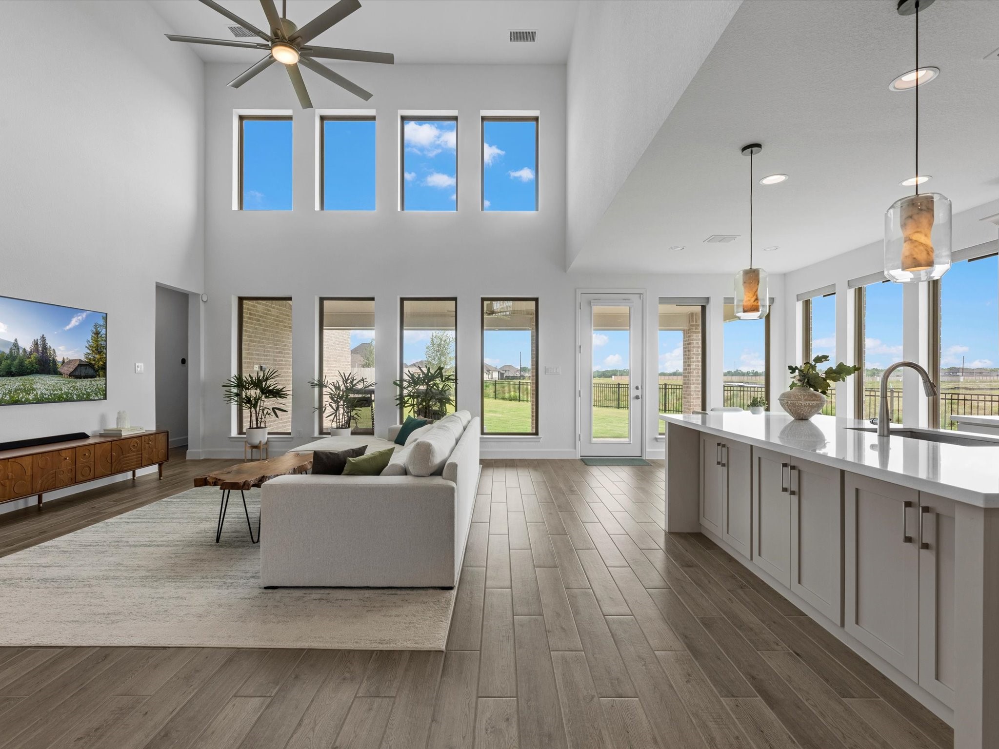 18714 Pistachio Way Manvel, TX 77578 - Photo 7 of 48 The soaring two-story family room is the heart of the home, featuring walls of windows that frame the expansive backyard and flood the space with natural light.