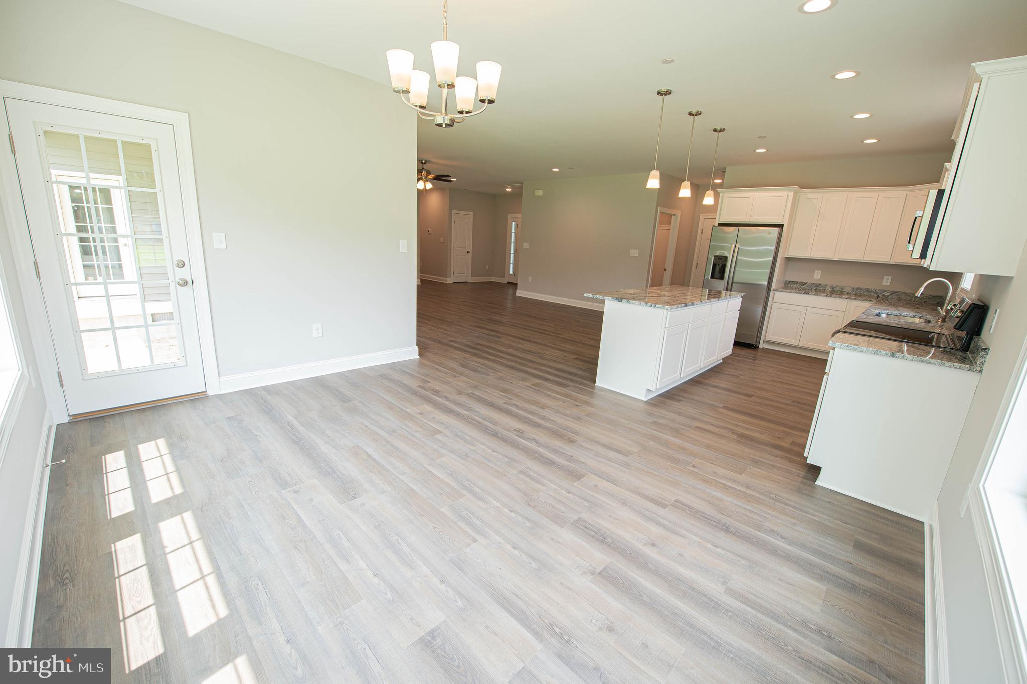22372 Concord Pond Road Georgetown, DE 19947 - Photo 16 of 43 a view of a room with kitchen island stainless steel appliances wooden floor and living room view