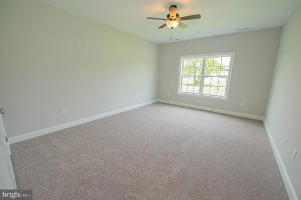 an empty room with a window and a fan