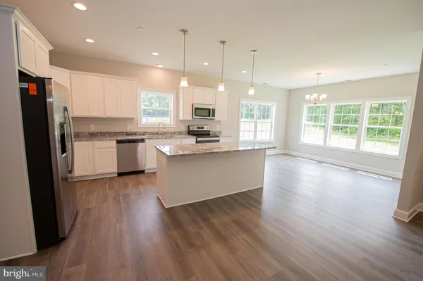 a large kitchen with stainless steel appliances granite countertop a stove a sink a refrigerator and a large window