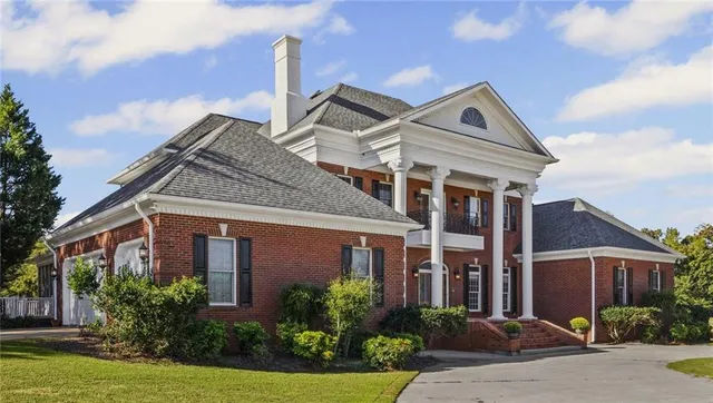 a view of a lake with a yard and large trees