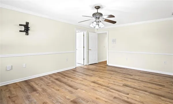 a bed sitting in a bedroom next to a lamp with a potted plant