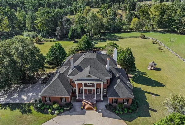 a view of a lake with a yard and large trees