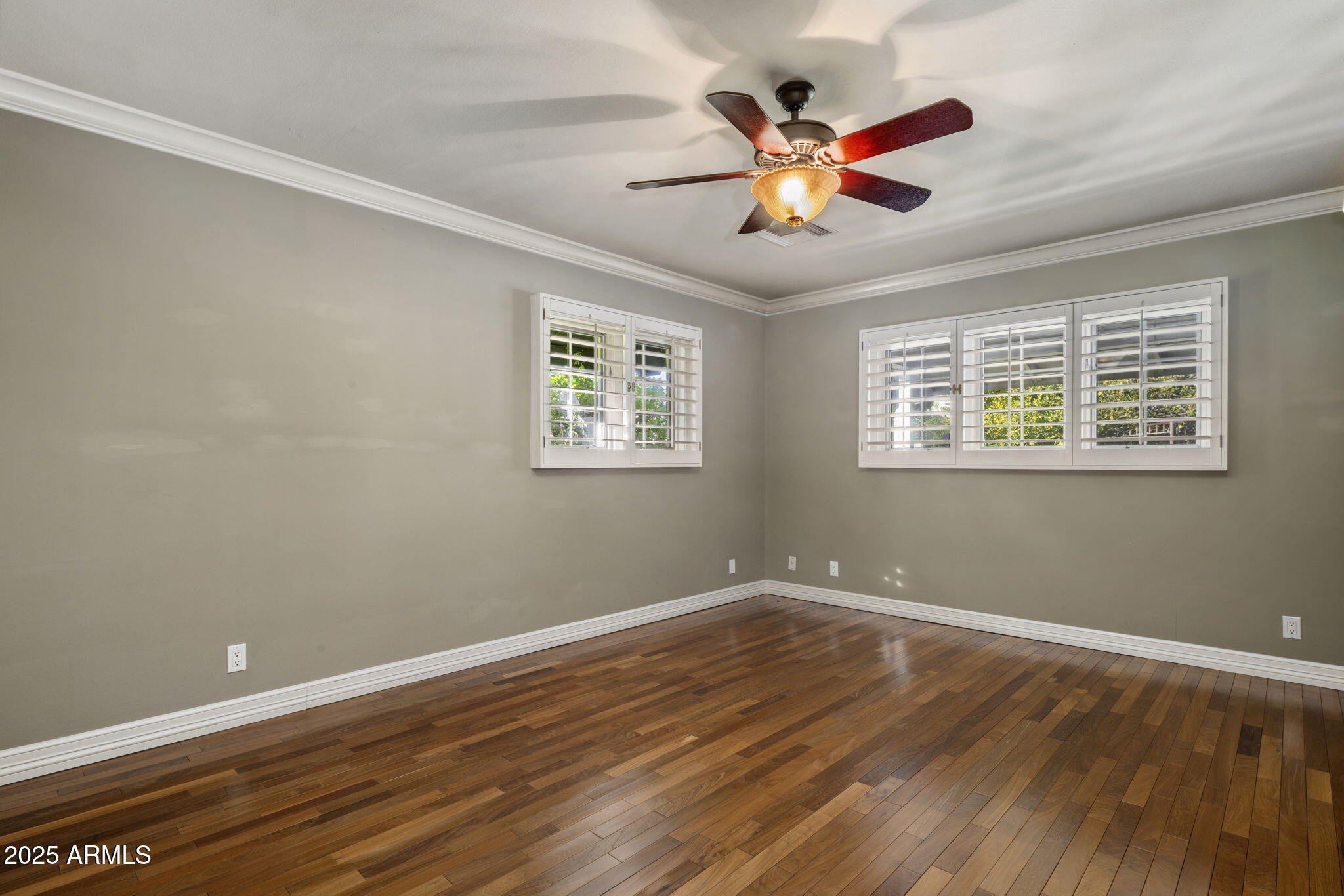 516 West Lawrence Road Phoenix, AZ 85013 - Photo 32 of 65 a view of an empty room with wooden floor and a ceiling fan