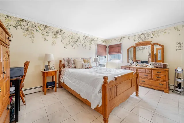 a spacious bedroom with a bed and a dresser in it