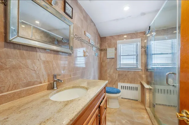 a bathroom with a granite countertop sink and a mirror