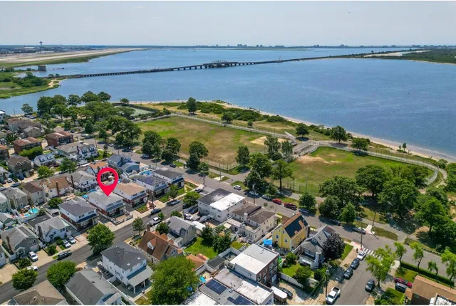 an aerial view of residential houses with outdoor space and lake view