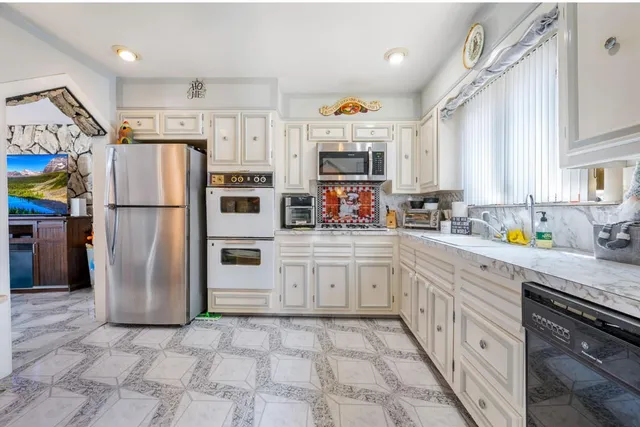 a kitchen with stainless steel appliances a refrigerator sink and microwave