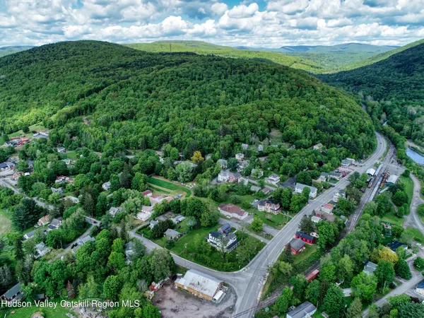 an aerial view of residential houses with outdoor space and trees