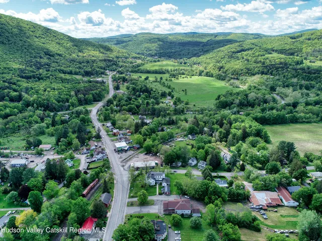 an aerial view of residential house with outdoor space and trees all around