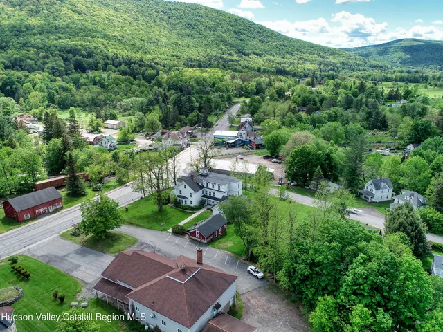 an aerial view of residential houses with outdoor space and trees all around