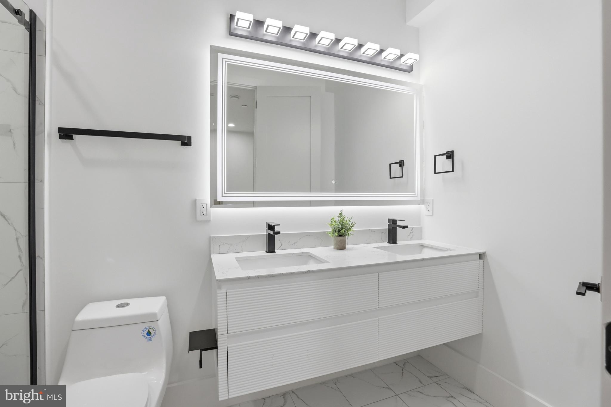 1140 Oates Street Northeast, Unit 101 Washington, DC 20002 - Photo 21 of 31 a bathroom with a sink a toilet and a mirror