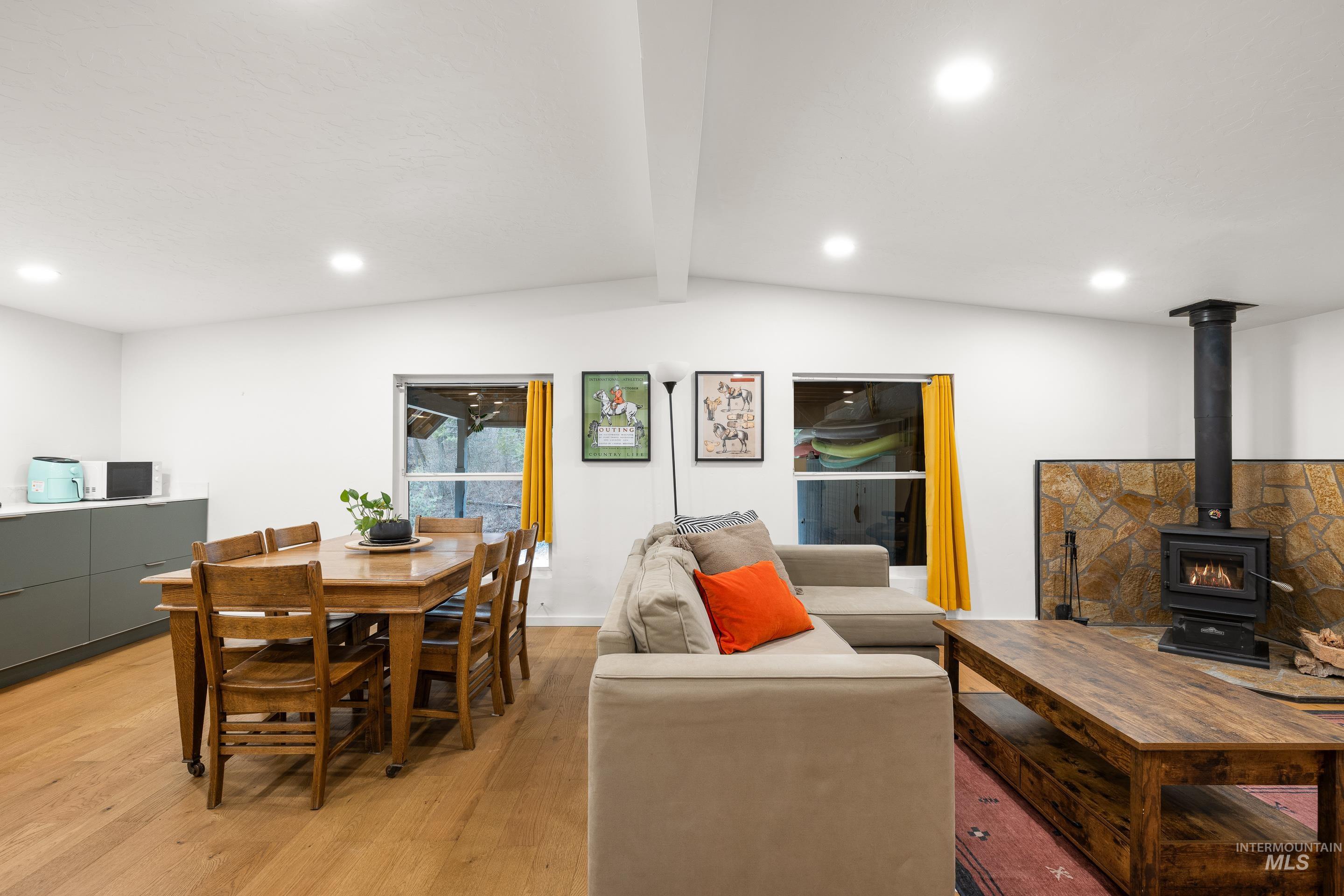 32 Sky Ridge Drive Garden Valley, ID 83622 - Photo 11 of 37 Living area featuring beamed ceiling, light wood-style flooring, recessed lighting, and a wood stove