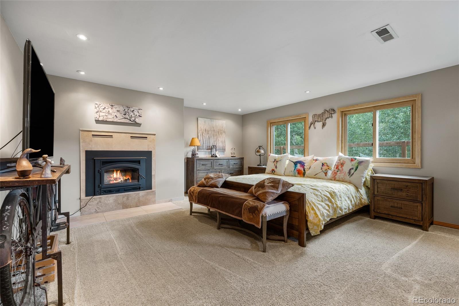 193 Twilight Terrace Drive Bailey, CO 80421 - Photo 24 of 50 a spacious bedroom with a bed and a fireplace
