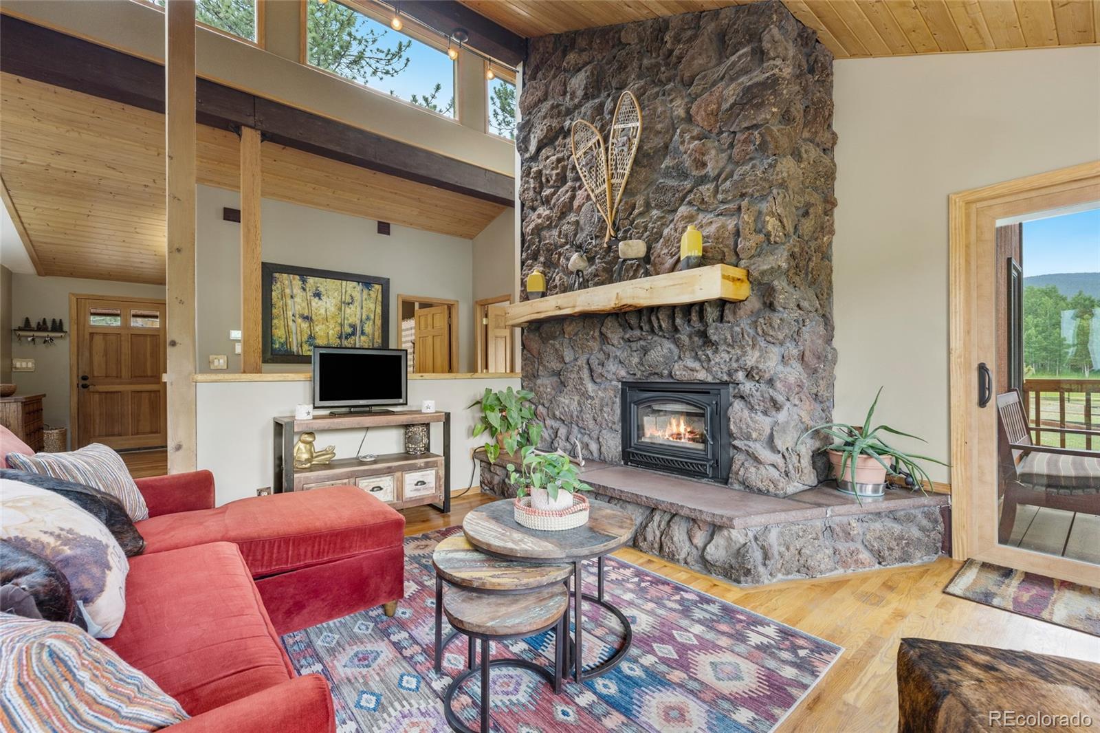 193 Twilight Terrace Drive Bailey, CO 80421 - Photo 3 of 50 a living room with furniture a flat screen tv and a fireplace