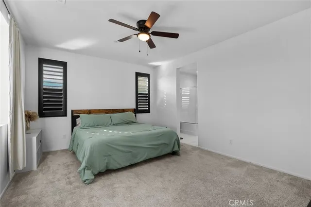 a bedroom with a bed and a ceiling fan