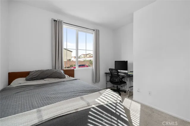 a bedroom with a bed and a computer on the desk