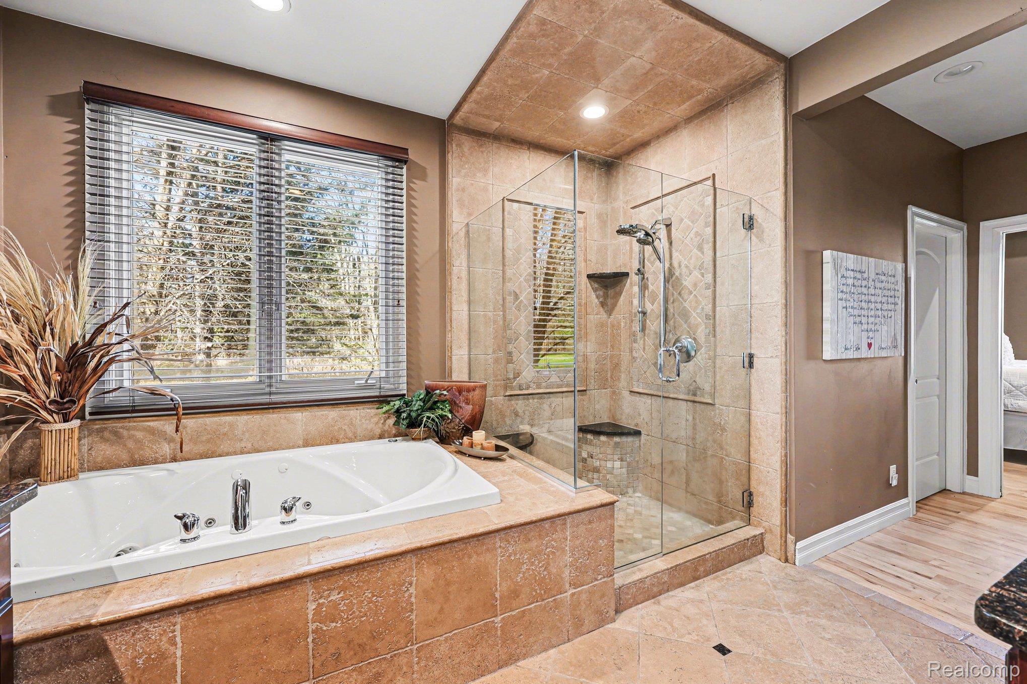 55256 Lee Road New Hudson, MI 48165 - Photo 17 of 28 Bathroom with ensuite bathroom, a shower stall, a tub with jets, light tile patterned floors, and recessed lighting
