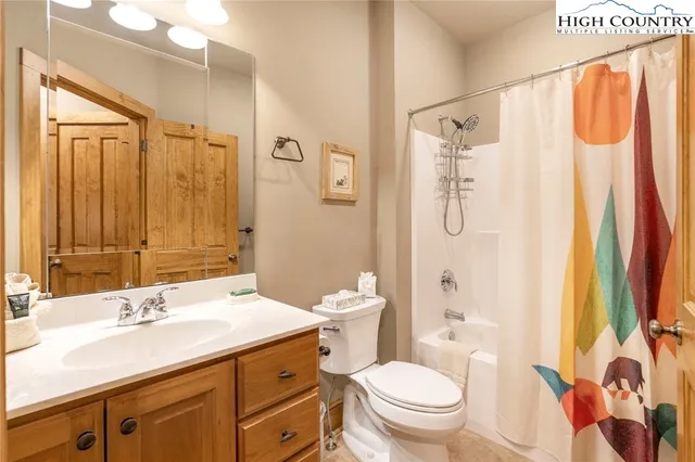 a bathroom with a sink toilet double vanity and shower
