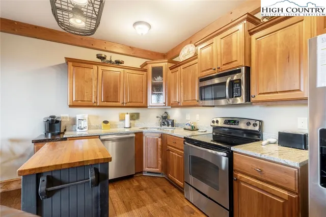 a kitchen with stainless steel appliances granite countertop a sink a stove a microwave and cabinets