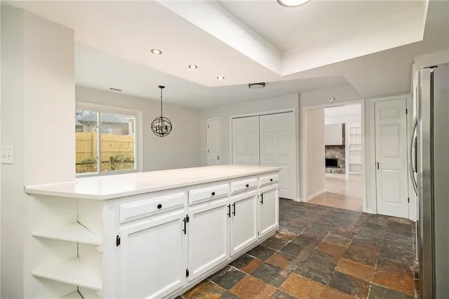 an empty room with a ceiling fan and windows