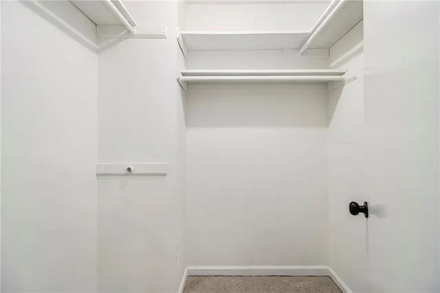 an empty room with wooden floor chandelier fan and windows