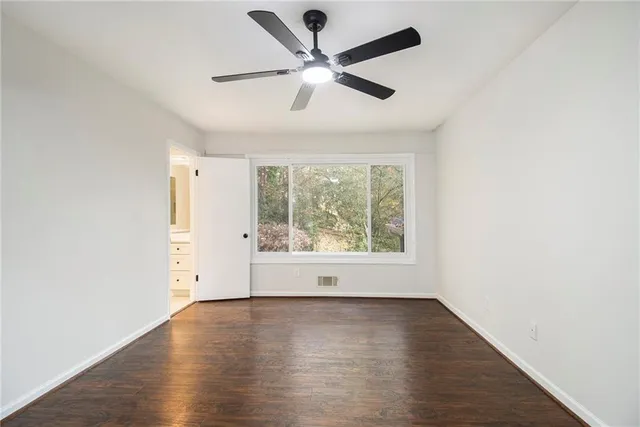 a view of a big room with wooden floor closet and windows