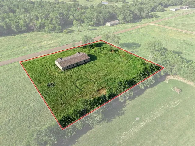a view of a yard with wooden fence